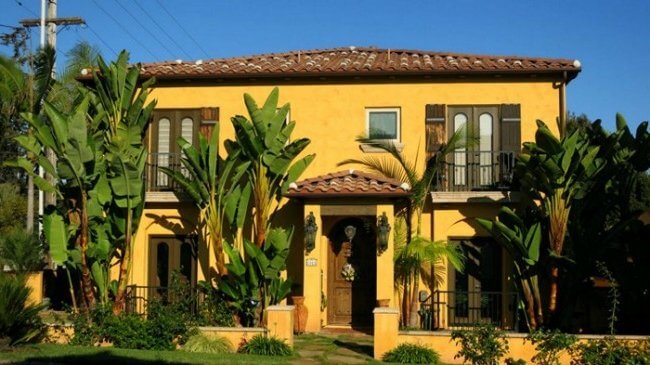 casa con paredes amarillas intensas y aberturas verde oliva